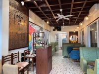 a restaurant with green chairs and a ceiling fan at The Lilly's Stories in Fort Kochi