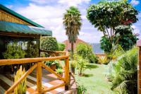 a garden with palm trees and a house at Umugano Villa in Kigali