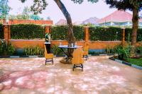 a patio with a table and chairs and a tree at Umugano Villa in Kigali