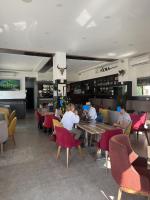 Super appartement avec 5 piscines en résidence في المنستير: مجموعة من الأشخاص يجلسون على الطاولات في مطعم