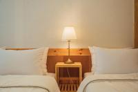 eine Lampe auf einem Tisch neben zwei Betten in der Unterkunft Hanok Stay Seowa in Gyeongju