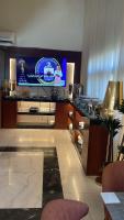 une chambre d'hôtel avec un bar et une télévision au mur dans l'établissement سكون سويت للشقق الفندقية, à Haïl