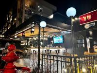 Un bar con una boca de incendios roja frente a un restaurante. en The Bridge Residence Hotel, en Kanchanaburi