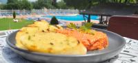a plate of food on a table near a pool at Hotel Genesis in Vratsa