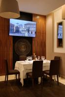 - une salle à manger avec une table, des chaises et un écran dans l'établissement Le Fontane del Re, à Caserte