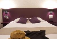 ロリアンにあるBRIT HOTEL LORIENT Le Kerotelの紫の壁のベッドルーム1室(大型ベッド1台付)
