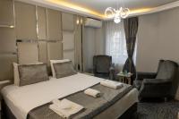 ブルサにあるGrand Heykel Hotelのベッドと椅子2脚があるホテルの部屋