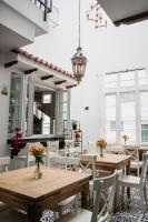 ein Esszimmer mit Holztischen und weißen Stühlen in der Unterkunft Hotel Boutique San Luis Mongui in Monguí