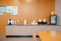 上海城市沙滩轩逸酒店 في Jinshan: مطبخ مزود بمنضدة عليها طاولة وآلة صنع القهوة