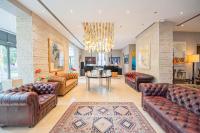 a living room with leather furniture and a chandelier at Century Hotel in Parma