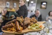 un piatto di cibo con salsiccia e patatine fritte di City Center Premium Belle Vue Apartments a Timişoara