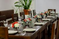 een lange tafel met borden en wijnglazen en bloemen bij Fontana Plaza Hotel in Villa de Leyva