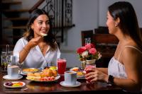 twee vrouwen aan een tafel eten bij Fontana Plaza Hotel in Villa de Leyva
