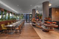 a restaurant with tables and chairs and a bar at Holiday Inn - Nairobi Two Rivers Mall by IHG in Nairobi