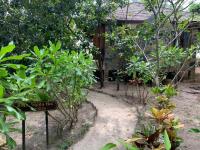 a garden with a sign in the middle of plants at Koh Jum Beach Villas "A member of Secret Retreats" in Ko Jum