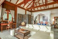 a living room with a couch and a table at Koh Jum Beach Villas "A member of Secret Retreats" in Ko Jum