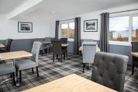 een eetkamer met tafels en stoelen en ramen bij The Rhiconich Hotel in Kinlochbervie