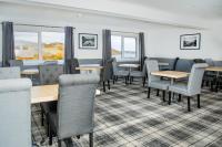 een eetkamer met tafels en stoelen en ramen bij The Rhiconich Hotel in Kinlochbervie
