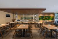 an empty restaurant with wooden tables and chairs at Swiss-Belexpress Cideng in Jakarta