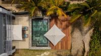 a building with a palm tree and a white umbrella at Stylia Villas in Trou dʼ Eau Douce
