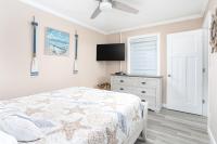 ein Schlafzimmer mit einem Bett und einem Flachbildfernseher in der Unterkunft ONE More Sandy Day - 2BR 2BA Beach Condo, Sleeps 6 in Myrtle Beach