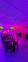 a dining room with purple lighting and tables and chairs at Hotel City Lights in Mexico City