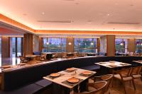a restaurant with tables and chairs and windows at Wingate by Wyndham Libo Center in Libo