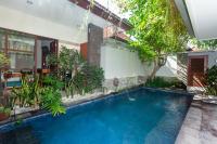 a swimming pool in the middle of a house at Naksa Homestay Sanur in Sanur