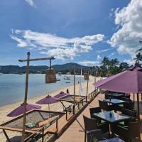 uma praia com mesas e guarda-sóis e o oceano em Prana Resort Nandana em Bangrak Beach