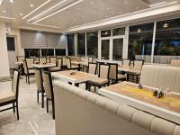 a restaurant with tables and chairs and windows at HOTEL MAA LAXMI PALACE in Deoghar