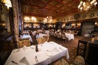 Un comedor con mesas y sillas blancas. en Hotel Bristol, en Oslo