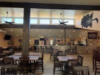 um restaurante com mesas, cadeiras e um bar em Flying L Ranch Resort & Golf Course em Bandera