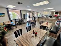 een leeg restaurant met houten tafels en stoelen bij The Inn at Mission Lakes in Desert Hot Springs