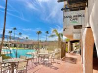 een patio met tafels en stoelen naast een zwembad bij The Inn at Mission Lakes in Desert Hot Springs