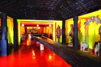 a hallway of a building with colorful walls and red floors at Ginger House Museum Hotel in Cochin