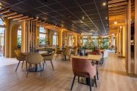 a dining room with tables and chairs and windows at Fletcher Boutique Hotel De Mallejan in Vierhouten