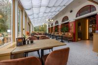 a restaurant with tables and chairs and windows at Fletcher Boutique Hotel De Mallejan in Vierhouten
