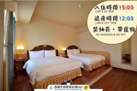 a hotel room with two beds and a sign at Goodness Hotel in Kaohsiung