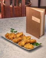 een bord eten op een tafel naast een boek bij Casa do Marujo e Casa do Mirone in Fornos de Algodres