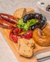 een bord met worst en andere etenswaren op een snijplank bij Casa do Marujo e Casa do Mirone in Fornos de Algodres