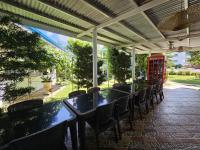 um pátio com mesas e cadeiras e uma cabine telefônica em Palanas By The Sea em Boljoon