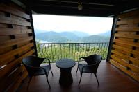 a table and four chairs on a balcony with a view at Cingjing Four Seasons B&amp;B in Ren&#39;ai