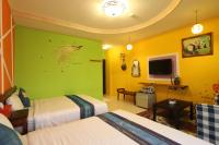 a hotel room with two beds and a green wall at Kenting Diack Inn in Hengchun South Gate