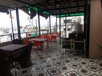 a restaurant with tables and chairs on a balcony at Jag Niwas Guest House & pure veg restaurant in Udaipur