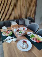 维尔科沃Котеджне містечко «Clover»的一张木桌，上面摆放着食物盘子