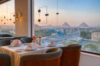 a table in a restaurant with a view of pyramids at Mazar Pyramids Hotel in Cairo