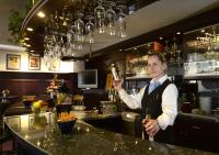 a woman standing at a bar holding a wine glass at Hotel Bavaria Brehna in Brehna