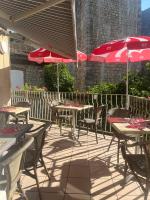 un patio con mesas, sillas y sombrillas en hotel restaurant le saint nazaire, en Saint-Nazaire-en-Royans