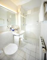 a white bathroom with a toilet and a sink at Hotel Bavaria Brehna in Brehna