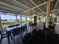 um restaurante com mesas e cadeiras na praia em Palanas By The Sea em Boljoon